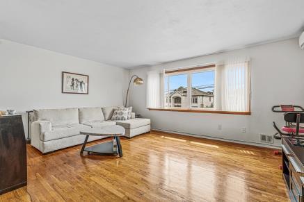 Sunlit living room with hardwood floors in a Howard Beach, Queens NY home for sale — Homes by Agatha