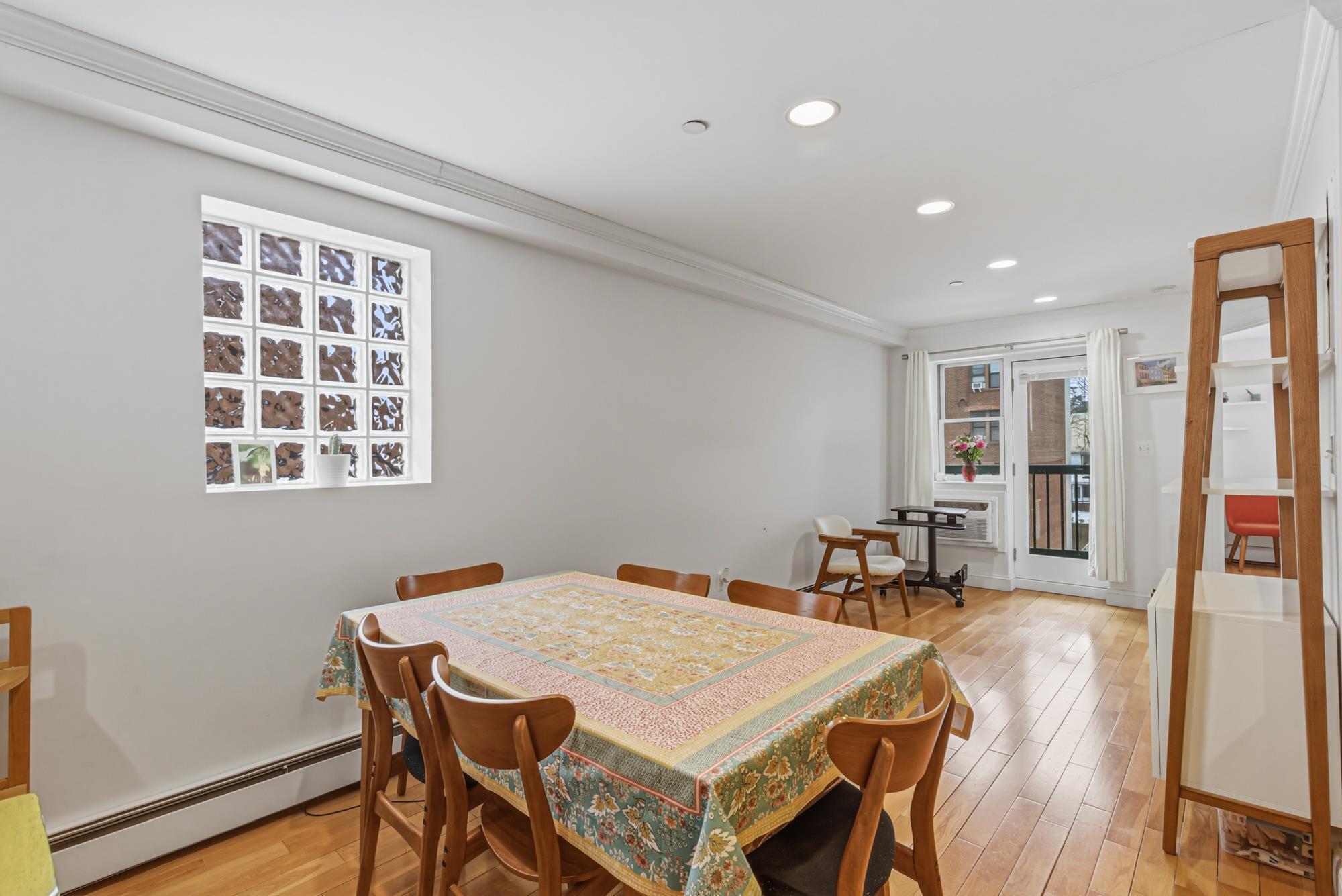 Dining area with hardwood floors and glass-block window in a Richmond Hill, Queens NY condo for sale — Homes by Agatha