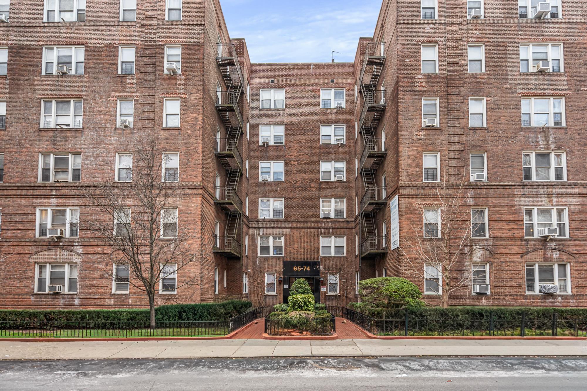 Front exterior of the pre-war brick co-op building at 65-74 Saunders Street, Rego Park, NY — Homes by Agatha