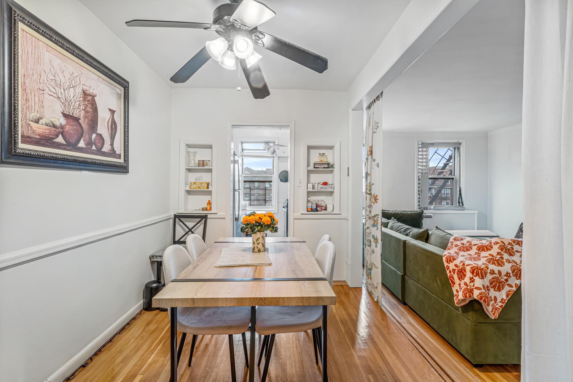 Dining area with hardwood floors open to the living room in a Rego Park, Queens NY co-op for sale at 65-74 Saunders Street 6J — Homes by Agatha