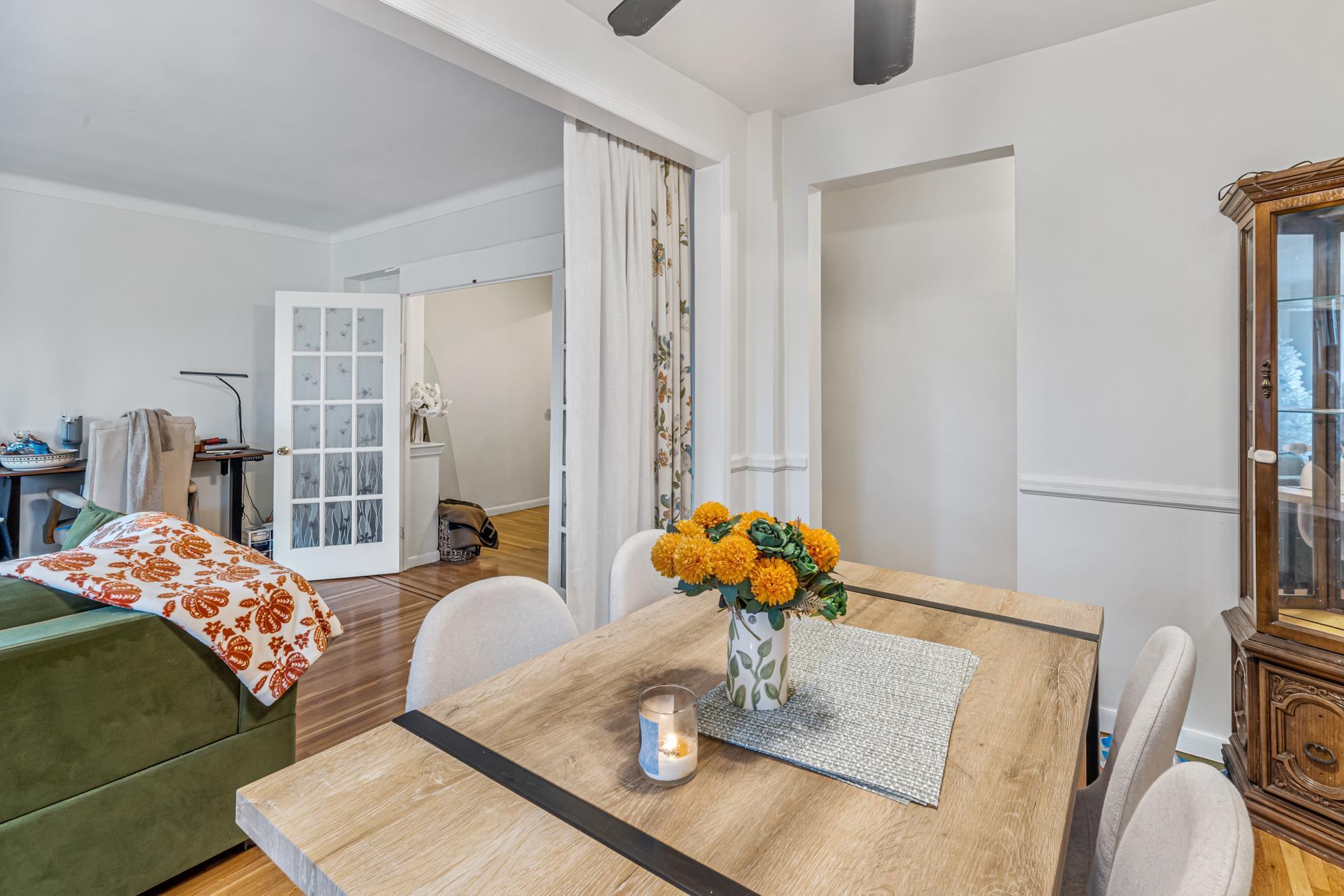 Dining and living area with hardwood floors in a Rego Park, Queens NY co-op for sale at 65-74 Saunders Street 6J — Homes by Agatha