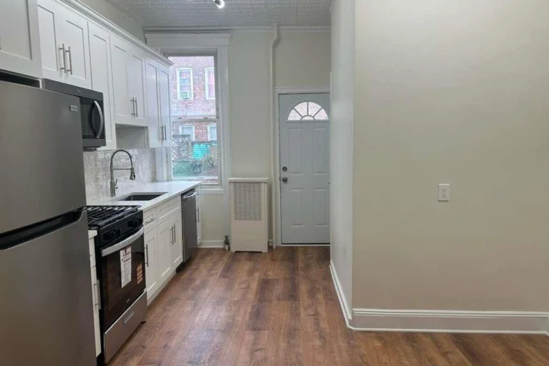 Renovated kitchen with stainless steel appliances in a Woodhaven, Queens NY apartment for rent at 88-23 85th Street — Homes by Agatha
