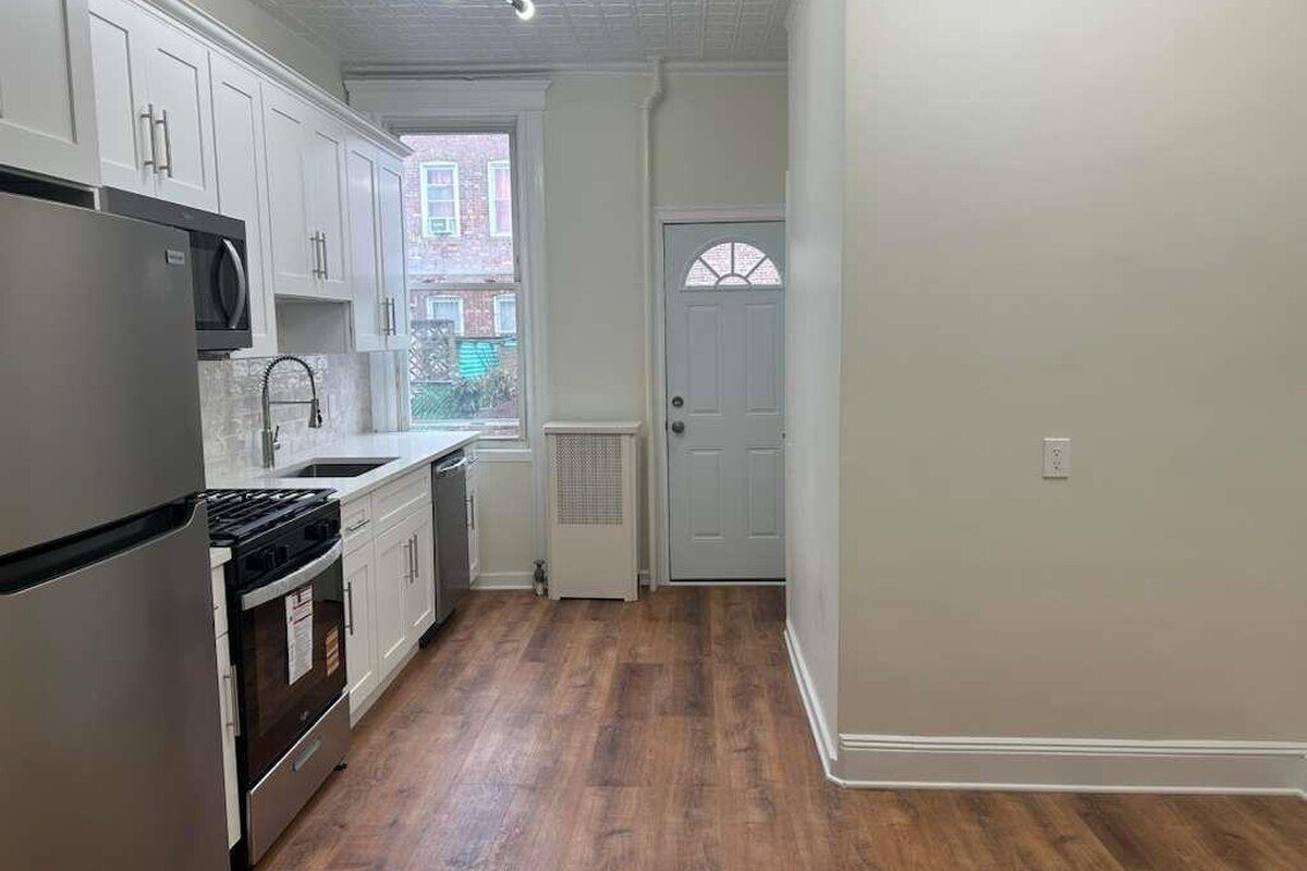 Renovated kitchen with stainless steel appliances in a Woodhaven, Queens NY apartment for rent at 88-23 85th Street — Homes by Agatha