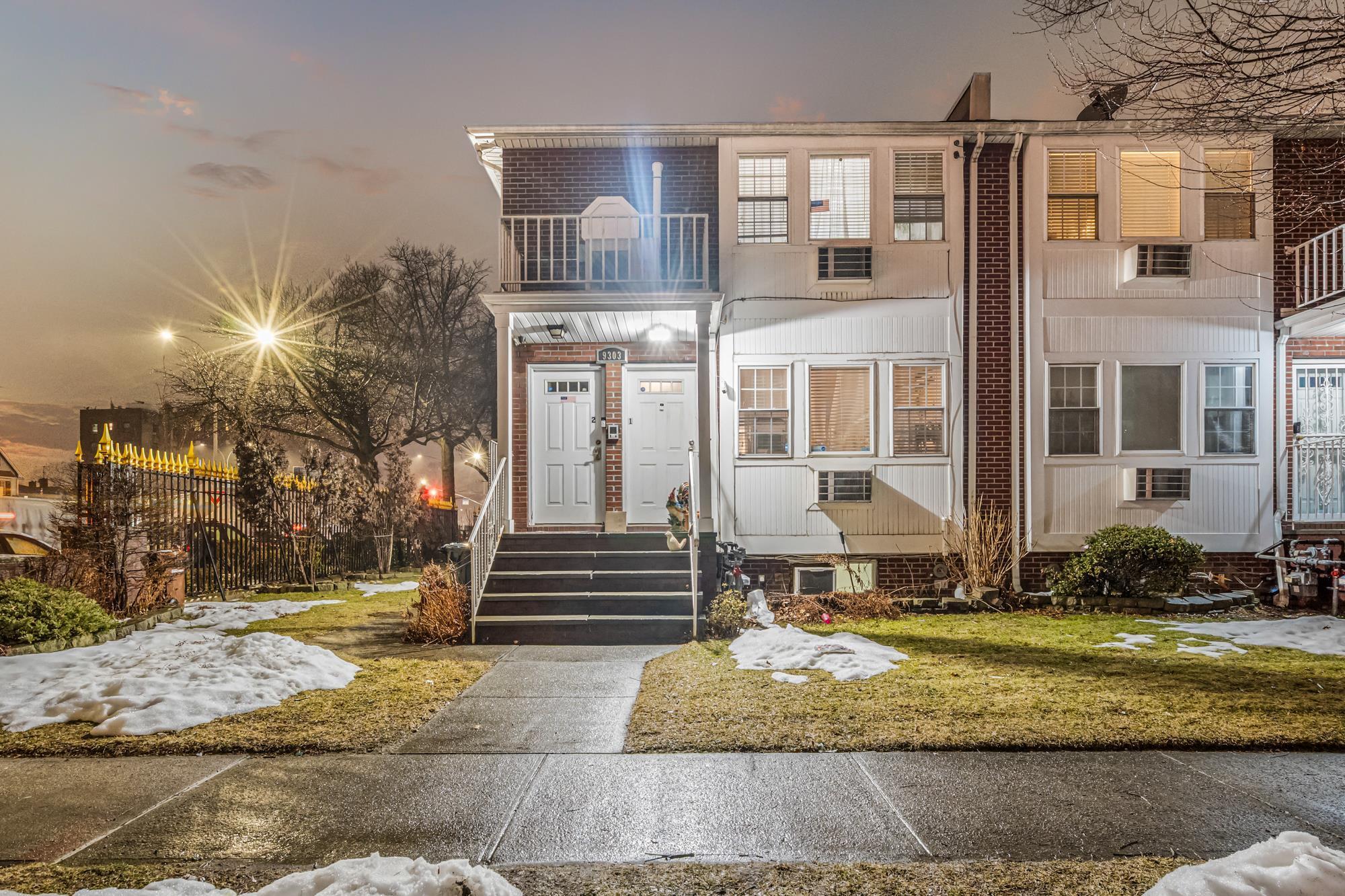 Twilight exterior of a brick two-family home for sale at 93-03 90th Avenue, Woodhaven, Queens NY — Homes by Agatha